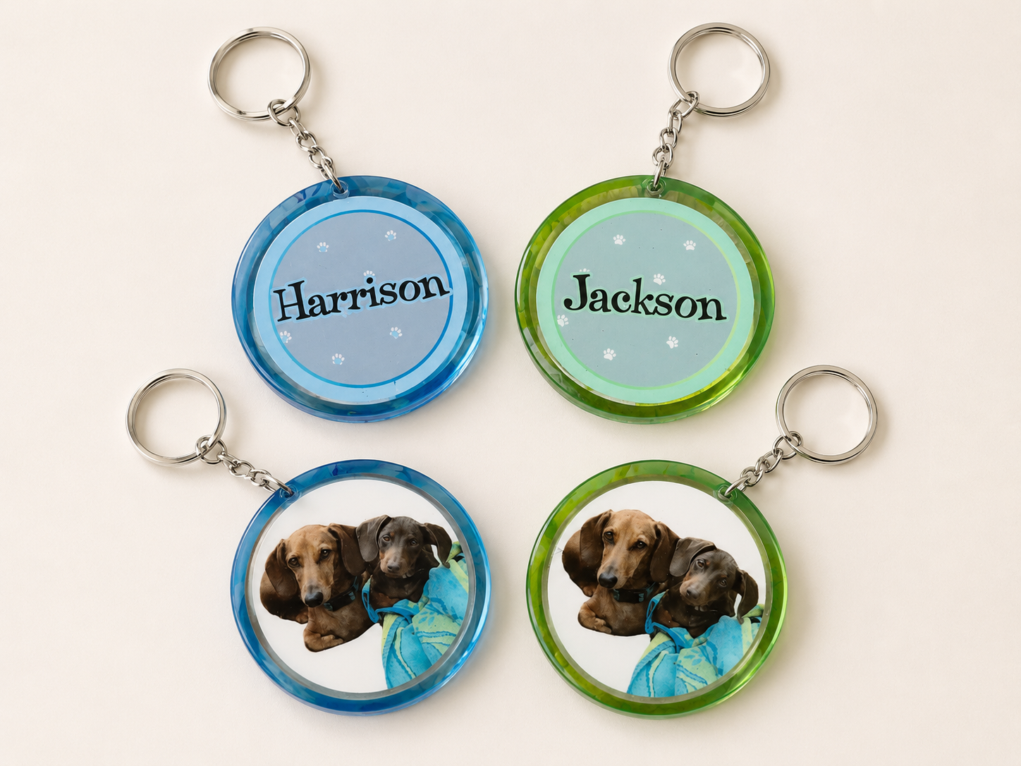 Two-sided blue and green paw print pet keychains for Harrison and Jackson