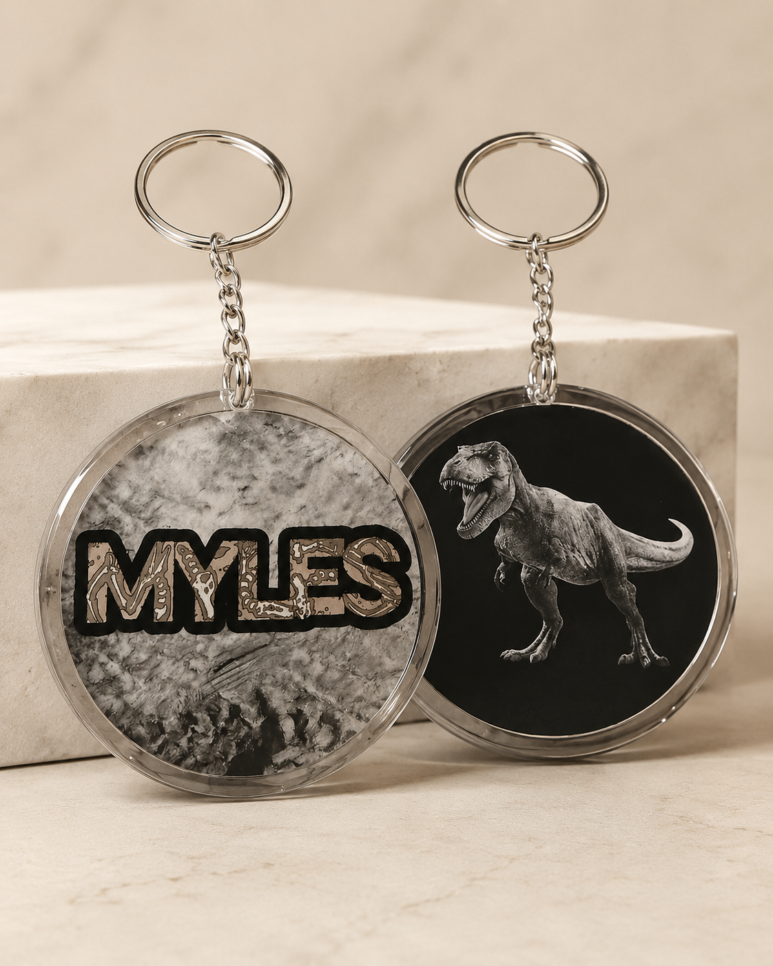 Gray personalized keychain with Myles name and dinosaur artwork